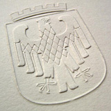Ein Abdruck einer Prägepresse - zu sehen ist ein Siegel